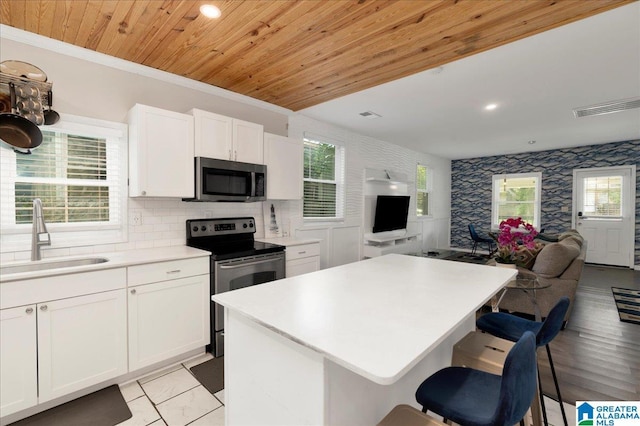 4808 S 3rd Ave, Birmingham, AL 35222 - kitchen featuring appliances with stainless steel finishes, a sink, open floor plan, white cabinetry, and wood ceiling