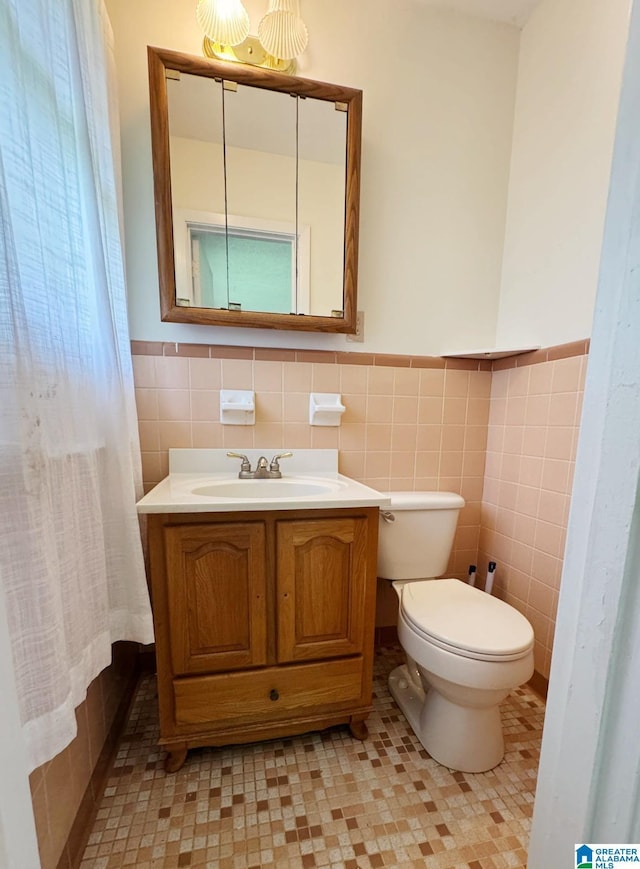 1315 Gloria Ln, Weaver, AL 36277 - bathroom with tile walls, toilet, vanity, and wainscoting