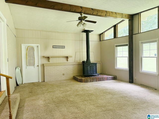 1315 Gloria Ln, Weaver, AL 36277 - unfurnished living room featuring a wood stove, carpet flooring, and ceiling fan