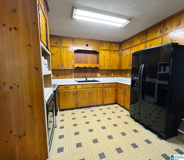 1315 Gloria Ln, Weaver, AL 36277 - kitchen with black refrigerator with ice dispenser, a sink, a textured ceiling, brown cabinetry, and light countertops