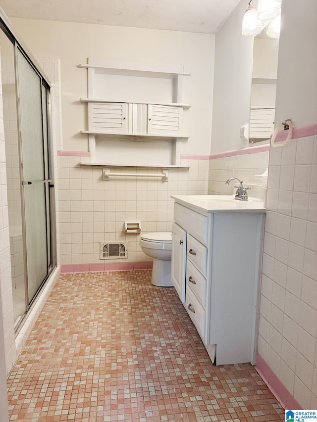 1315 Gloria Ln, Weaver, AL 36277 - full bath with tile walls, a stall shower, vanity, toilet, and wainscoting