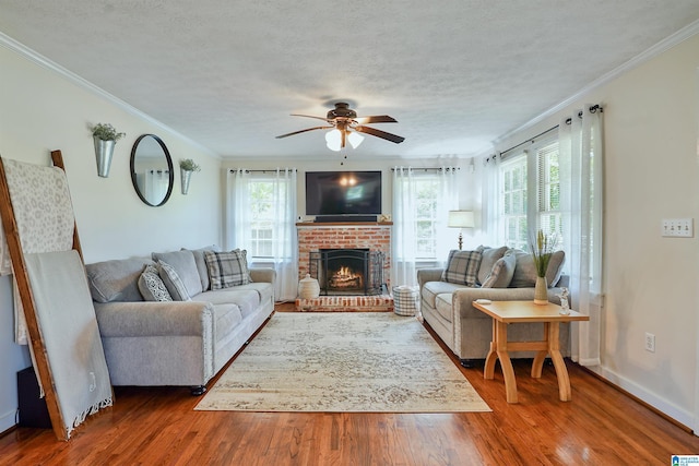 1693 4th Ave N, Clanton, AL 35045 - living area featuring plenty of natural light, ceiling fan, wood finished floors, crown molding, and a brick fireplace