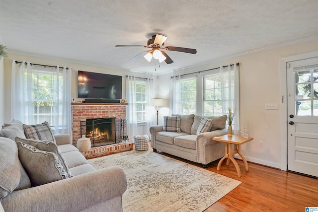 1693 4th Ave N, Clanton, AL 35045 - living room with ceiling fan, wood finished floors, ornamental molding, a brick fireplace, and a textured ceiling