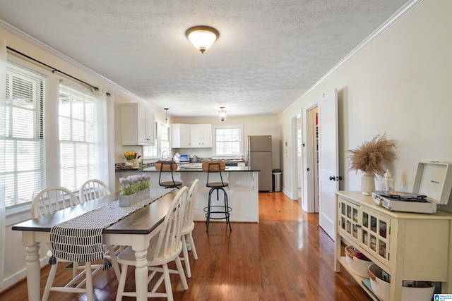 1693 4th Ave N, Clanton, AL 35045 - dining area featuring a textured ceiling, wood finished floors, crown molding, and baseboards