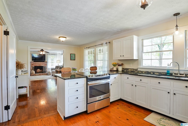 1693 4th Ave N, Clanton, AL 35045 - kitchen with electric stove, a sink, a peninsula, light wood-style flooring, and healthy amount of natural light