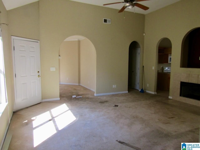 221 High Ridge Dr, Pelham, AL 35124 - unfurnished living room featuring high vaulted ceiling, arched walkways, a ceiling fan, carpet, and a fireplace