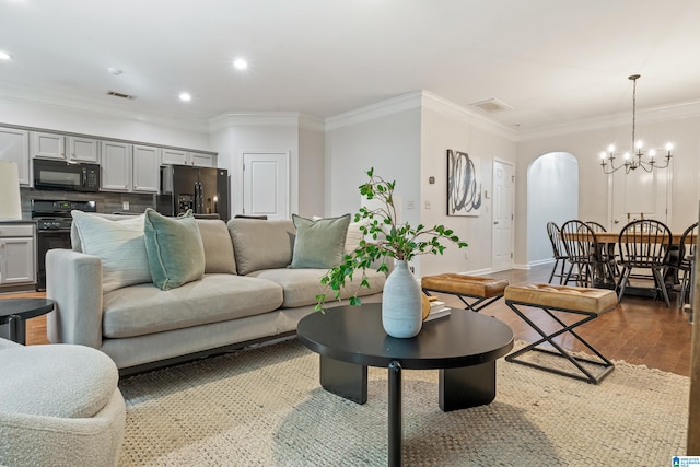 1033 Inverness Cove Way, Hoover, AL 35242 - living area featuring arched walkways, a chandelier, ornamental molding, dark wood-type flooring, and baseboards