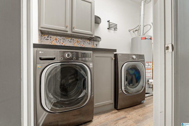 1033 Inverness Cove Way, Hoover, AL 35242 - laundry area with cabinet space, gas water heater, washing machine and clothes dryer, and light wood-style floors