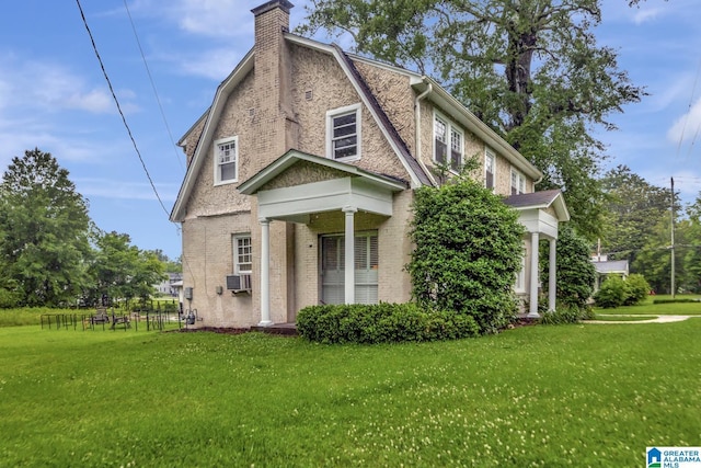 102 E Crest Rd, Hueytown, AL 35023 - view of front of home with a front yard, a chimney, a gambrel roof, brick siding, and cooling unit