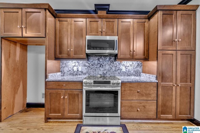 1700 Leisure Ln NW, Cullman, AL 35055 - kitchen featuring appliances with stainless steel finishes, light wood-type flooring, and light stone countertops