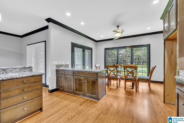 1700 Leisure Ln NW, Cullman, AL 35055 - kitchen with crown molding, light wood finished floors, light stone countertops, baseboards, and recessed lighting