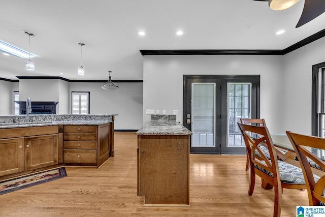 1700 Leisure Ln NW, Cullman, AL 35055 - kitchen featuring a sink, ornamental molding, brown cabinetry, light wood-style floors, and a fireplace
