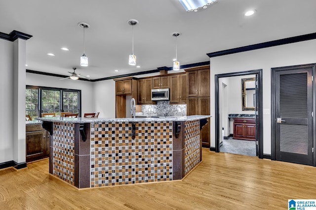 1700 Leisure Ln NW, Cullman, AL 35055 - kitchen featuring stainless steel microwave, crown molding, light wood-type flooring, decorative light fixtures, and recessed lighting