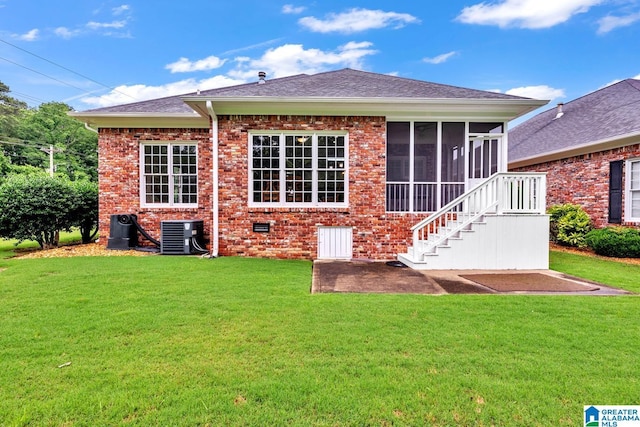 1700 Leisure Ln NW, Cullman, AL 35055 - rear view of property with central AC unit, a sunroom, a lawn, and brick siding