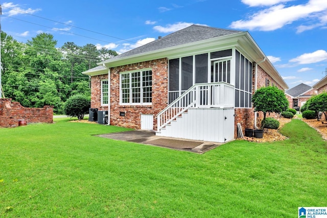1700 Leisure Ln NW, Cullman, AL 35055 - rear view of property with brick siding, a sunroom, a yard, a shingled roof, and a patio