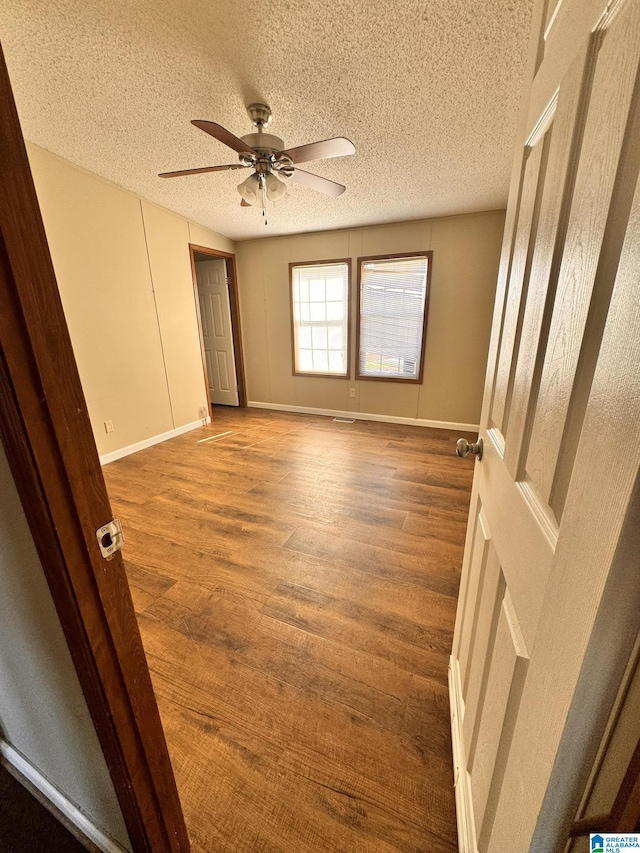 11791 Shoal Creek Dr, Ashville, AL 35953 - empty room with a ceiling fan, a textured ceiling, wood finished floors, and baseboards