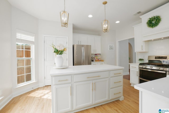 2014 Madison Cir, Chelsea, AL 35043 - kitchen featuring stainless steel appliances, arched walkways, light wood finished floors, white cabinets, and pendant lighting