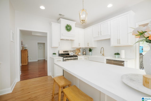 2014 Madison Cir, Chelsea, AL 35043 - kitchen featuring stainless steel appliances, a sink, light wood-type flooring, light countertops, and white cabinetry
