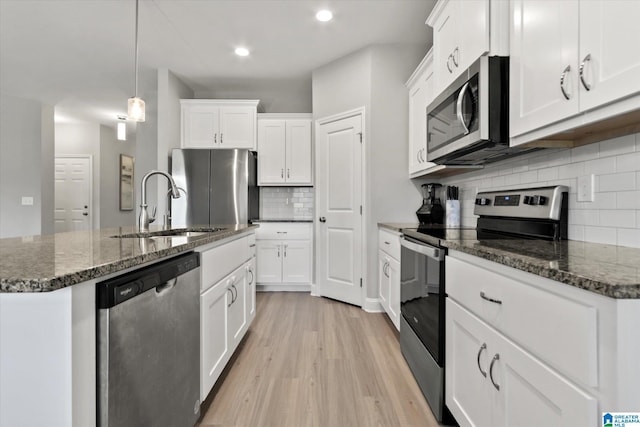 27281 Mckenna Dr, Athens, AL 35613 - kitchen with stainless steel appliances, a sink, light wood finished floors, decorative backsplash, and white cabinetry