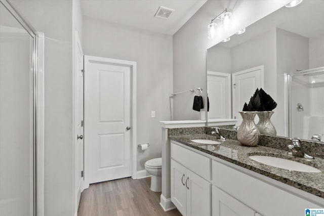 27281 Mckenna Dr, Athens, AL 35613 - bathroom featuring a shower stall, double vanity, toilet, wood finished floors, and baseboards