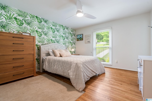 1355 Starcross Dr, Vestavia Hills, AL 35216 - bedroom featuring wallpapered walls, light wood finished floors, baseboards, ceiling fan, and an accent wall