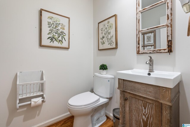 1355 Starcross Dr, Vestavia Hills, AL 35216 - half bathroom featuring toilet, vanity, wood finished floors, and baseboards