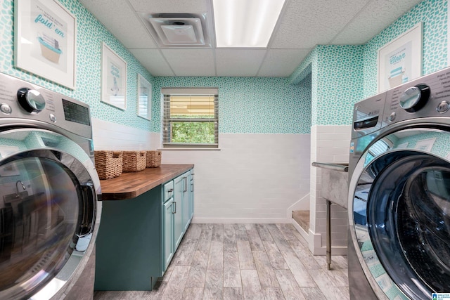 1355 Starcross Dr, Vestavia Hills, AL 35216 - laundry room with washer / dryer, cabinet space, light wood-style flooring, wallpapered walls, and tile walls
