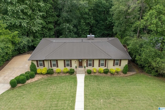 1355 Starcross Dr, Vestavia Hills, AL 35216 - view of front of property featuring a front lawn, stucco siding, metal roof, a chimney, and driveway