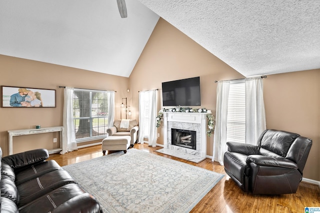 246 Park Place Way, Alabaster, AL 35007 - living room with high vaulted ceiling, light wood-type flooring, baseboards, a high end fireplace, and ceiling fan