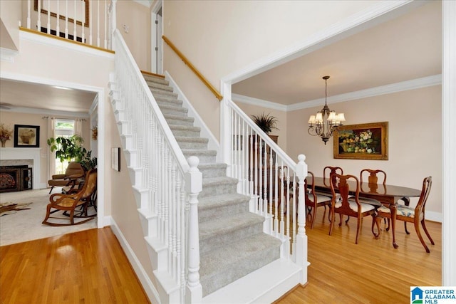 1222 Eagle Park Rd, Birmingham, AL 35242 - staircase with crown molding, wood finished floors, a chandelier, a premium fireplace, and baseboards