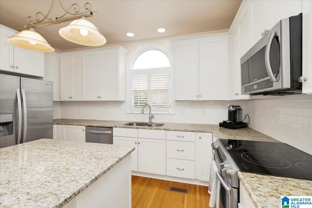 1222 Eagle Park Rd, Birmingham, AL 35242 - kitchen featuring appliances with stainless steel finishes, a sink, white cabinets, light wood-style floors, and light stone countertops