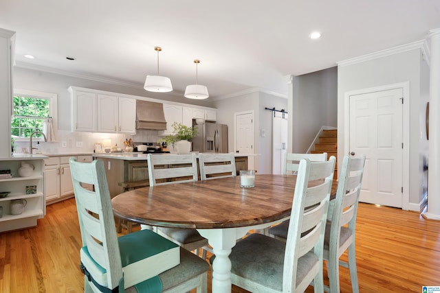 208 Maple Trce, Hoover, AL 35244 - dining space with a barn door, light wood-style flooring, ornamental molding, recessed lighting, and stairs