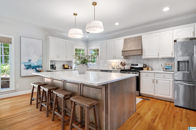 208 Maple Trce, Hoover, AL 35244 - kitchen with stainless steel appliances, premium range hood, a kitchen island, light wood-style floors, and white cabinetry