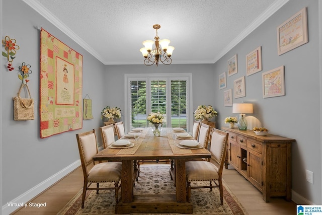 2028 Moncrief Rd, Gardendale, AL 35071 - dining space featuring light wood finished floors, a chandelier, ornamental molding, a textured ceiling, and baseboards