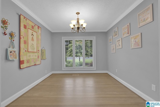 2028 Moncrief Rd, Gardendale, AL 35071 - unfurnished dining area featuring a chandelier, a textured ceiling, light wood-style flooring, crown molding, and baseboards