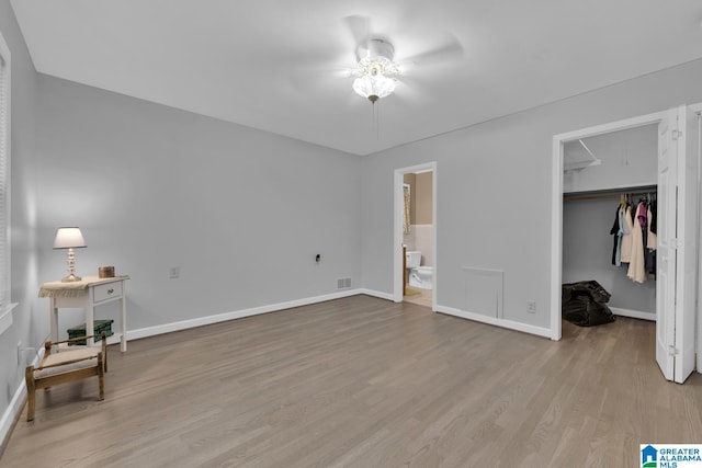 2028 Moncrief Rd, Gardendale, AL 35071 - unfurnished bedroom with light wood-style floors, a spacious closet, baseboards, connected bathroom, and a closet