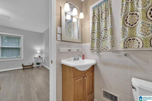 2028 Moncrief Rd, Gardendale, AL 35071 - bathroom featuring tile walls, wood finished floors, vanity, and toilet