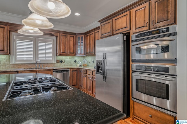 386 N Lake Rd, Birmingham, AL 35242 - kitchen featuring appliances with stainless steel finishes, a sink, crown molding, brown cabinetry, and backsplash