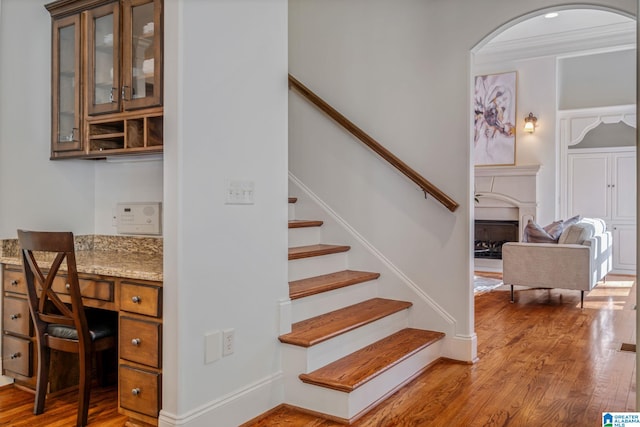 386 N Lake Rd, Birmingham, AL 35242 - staircase featuring wood finished floors, a fireplace, arched walkways, and built in study area