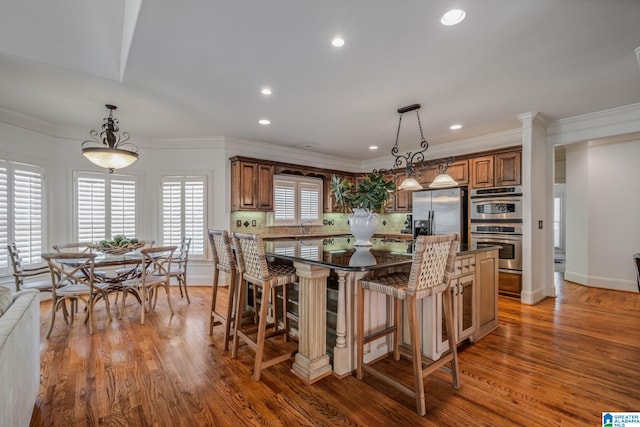386 N Lake Rd, Birmingham, AL 35242 - kitchen featuring appliances with stainless steel finishes, brown cabinetry, a center island, tasteful backsplash, and recessed lighting