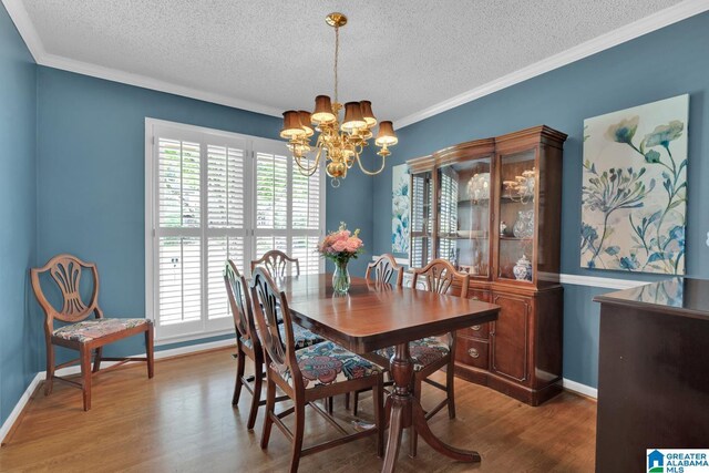 3258 Tyrol Ln, Vestavia Hills, AL 35216 - dining area with a chandelier, a textured ceiling, wood finished floors, ornamental molding, and baseboards