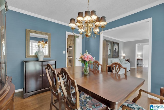 3258 Tyrol Ln, Vestavia Hills, AL 35216 - dining room featuring a chandelier, crown molding, wood finished floors, a textured ceiling, and baseboards