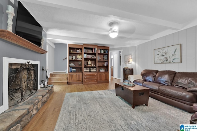 3258 Tyrol Ln, Vestavia Hills, AL 35216 - living area featuring beamed ceiling, wood finished floors, stairway, a ceiling fan, and a fireplace with raised hearth