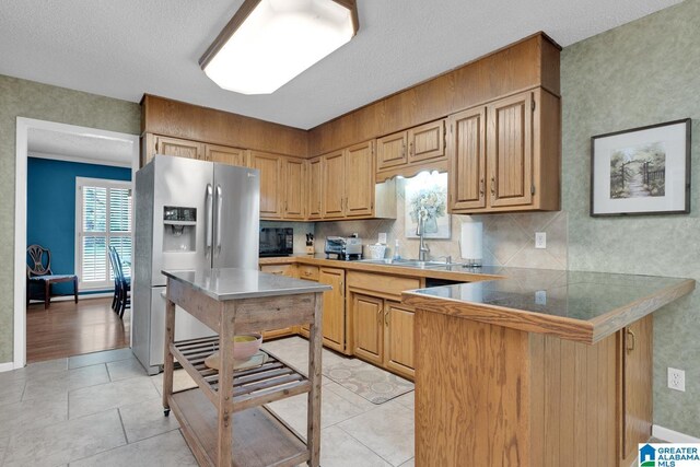 3258 Tyrol Ln, Vestavia Hills, AL 35216 - kitchen featuring stainless steel refrigerator with ice dispenser, a peninsula, a sink, a kitchen bar, and light tile patterned flooring