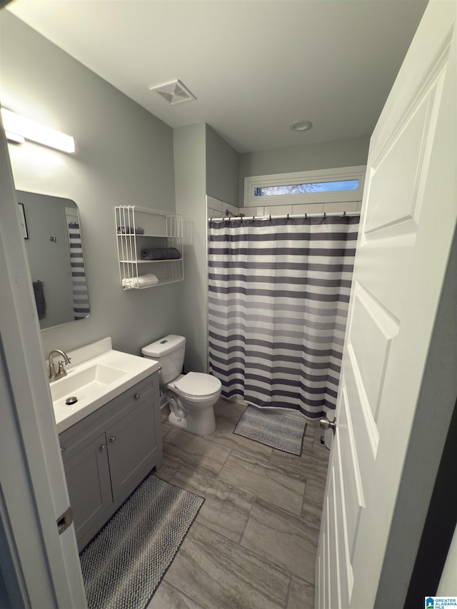 906 6th Ave W, Birmingham, AL 35204 - bathroom with vanity, toilet, and a shower with shower curtain