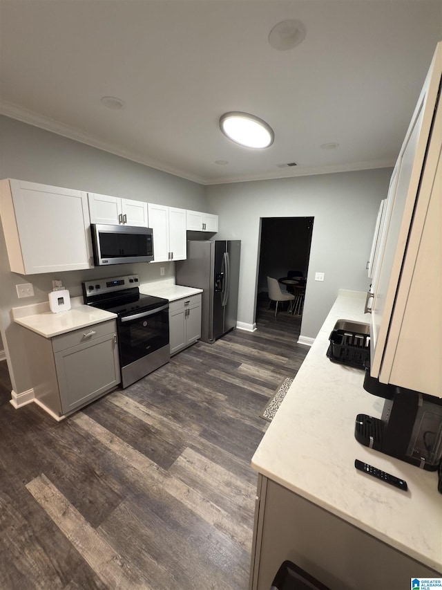 906 6th Ave W, Birmingham, AL 35204 - kitchen featuring stainless steel appliances, ornamental molding, dark wood-type flooring, baseboards, and gray cabinets