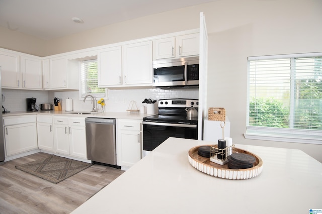 539 63rd St S, Birmingham, AL 35212 - kitchen featuring stainless steel appliances, light wood-style flooring, white cabinetry, and a sink