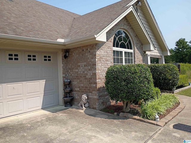 115 Clover St, Odenville, AL 35120 - entrance to property featuring roof with shingles, concrete driveway, a garage, and brick siding