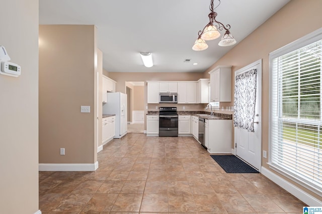 538 Forest Lakes Dr, Sterrett, AL 35147 - kitchen with appliances with stainless steel finishes, a sink, white cabinetry, baseboards, and hanging light fixtures