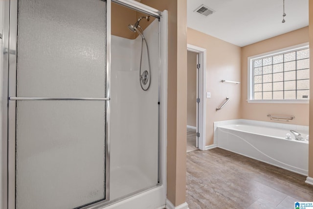 538 Forest Lakes Dr, Sterrett, AL 35147 - bathroom featuring wood finished floors, a stall shower, a bath, and baseboards